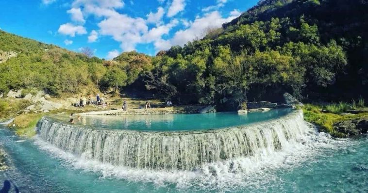 Thermal bath in benja filled with blue water and surrounded by green trees
