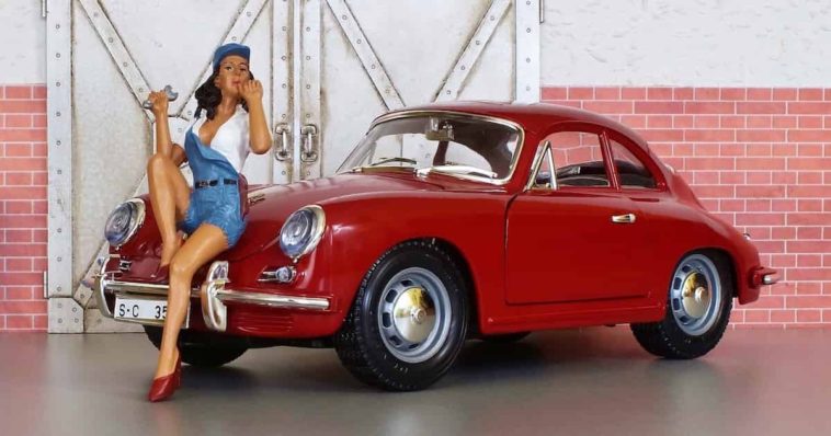 Classic red porsche 911 toy with a toy doll standing in front