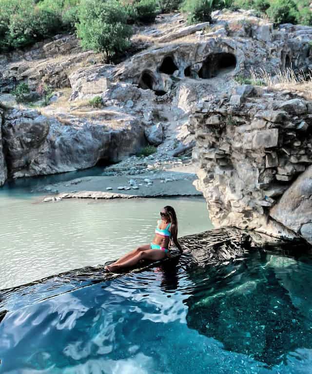 woman in blue bathsuit relaxing in thermal bath in benja