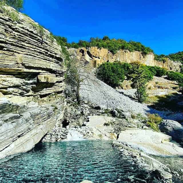 thermal bath in benja filled with blue water and surrounded by rocks