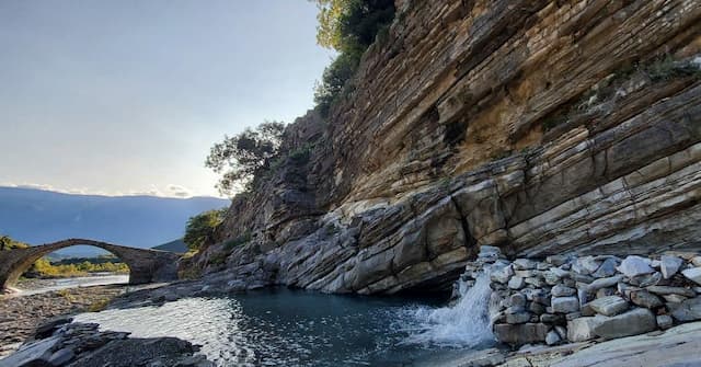 thermal bath in benja filled with dark blue water and surrounded by rocks