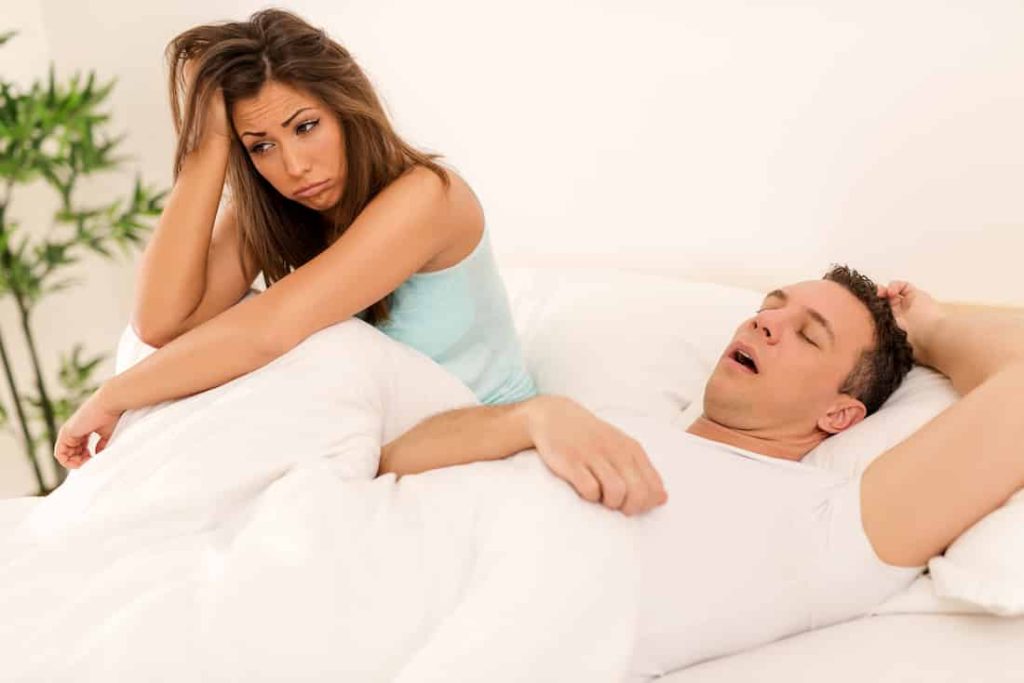 disappointed woman next to her man in bed
