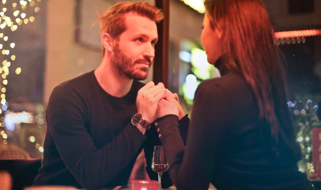 A couple looking at each other on a restaurant table