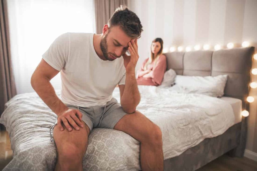 man annoyed by woman in bed