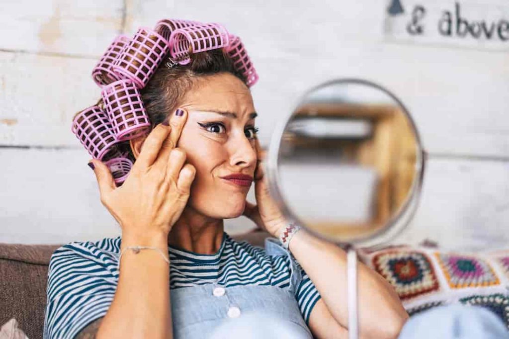 woman looking at herself in the mirror